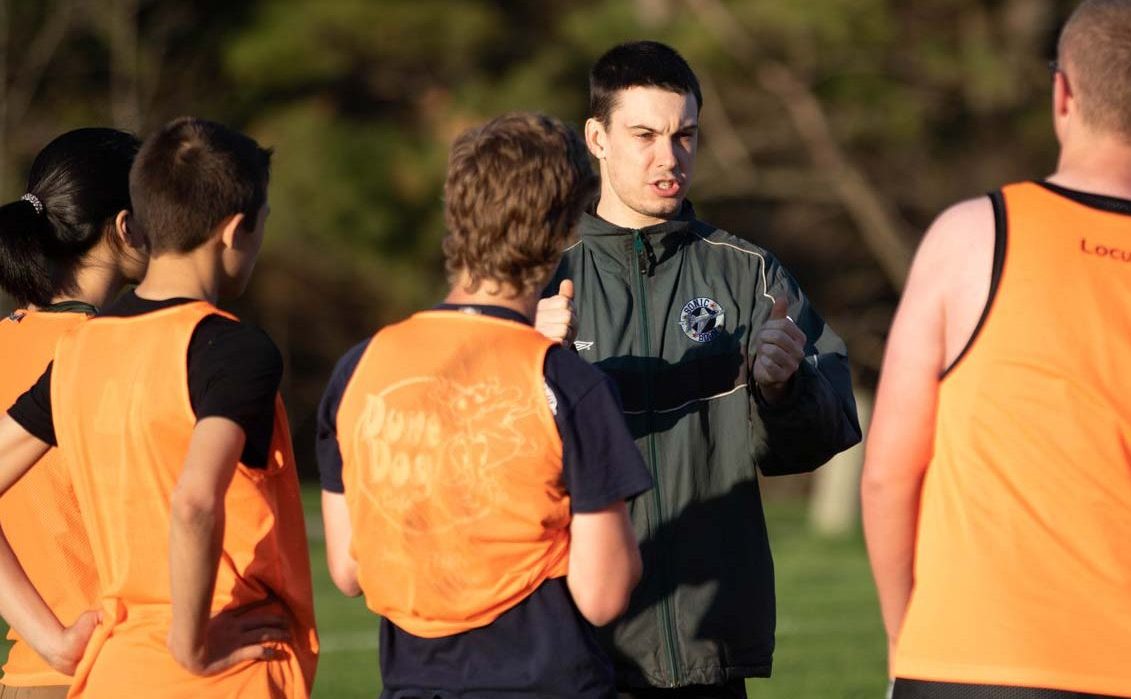 A coach describing a play to a group of youths